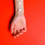 Photo of Person's Arm on Red Background