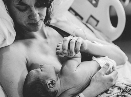 Monochrome Photograph of a Woman Carrying an Infant