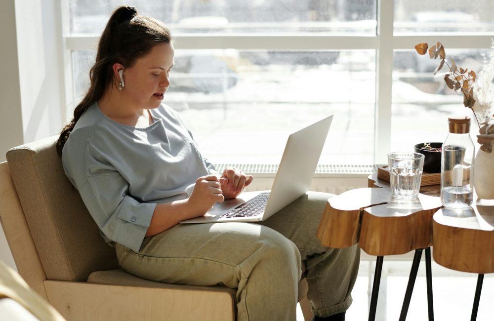 Girl Sitting On A Couch Using A Laptop