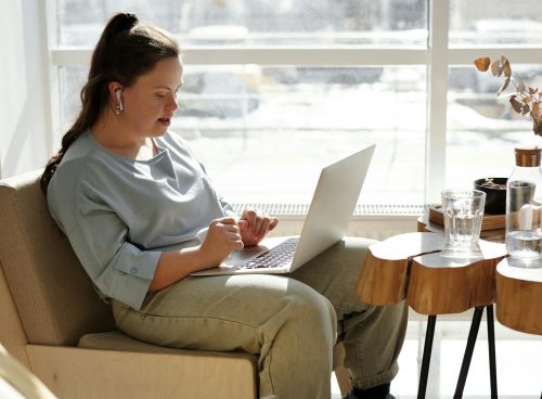 Girl Sitting On A Couch Using A Laptop