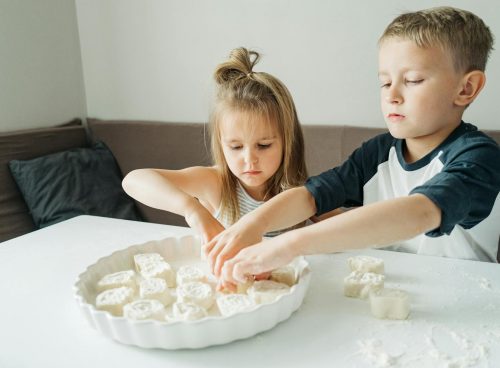 Girl in Blue and White Shirt Sitting Beside Girl in White Shirt