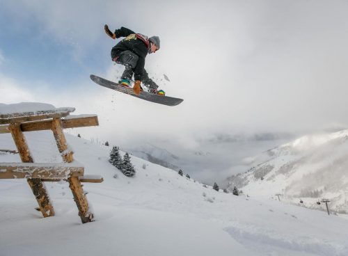 Man in Black Snowboard With Binding Performs a Jump