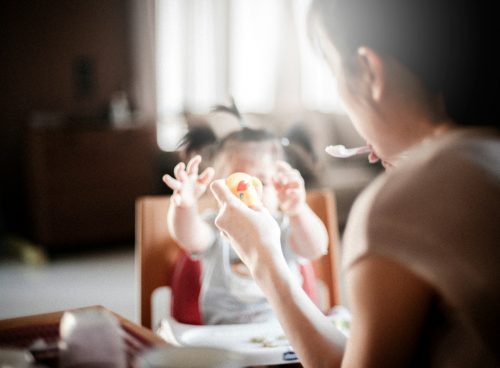 selective focus photography of woman feeding baby