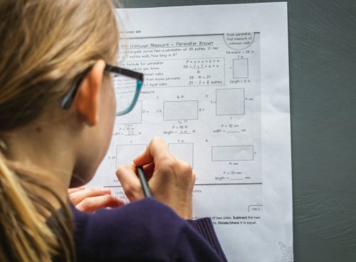woman in black framed eyeglasses holding pen