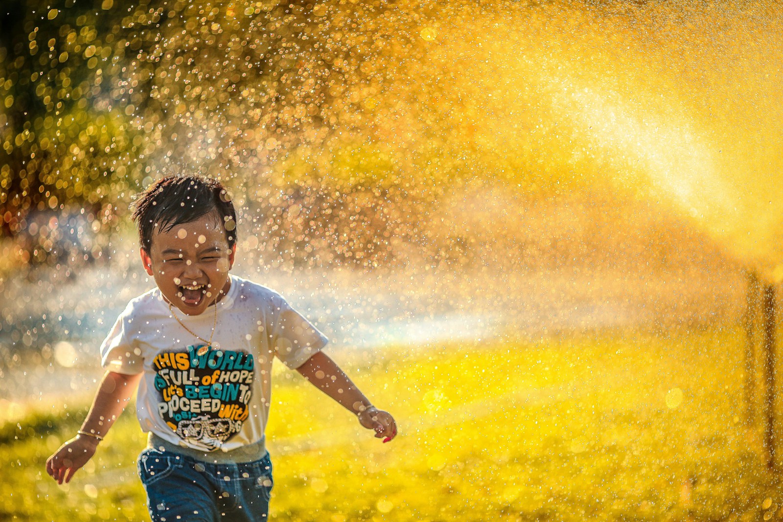 How to Help Your Child Build Resilience and Adapt to Change 1 a young boy running through a sprinkle of water