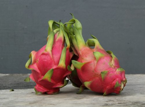 a couple of dragon fruit sitting on top of a wooden table