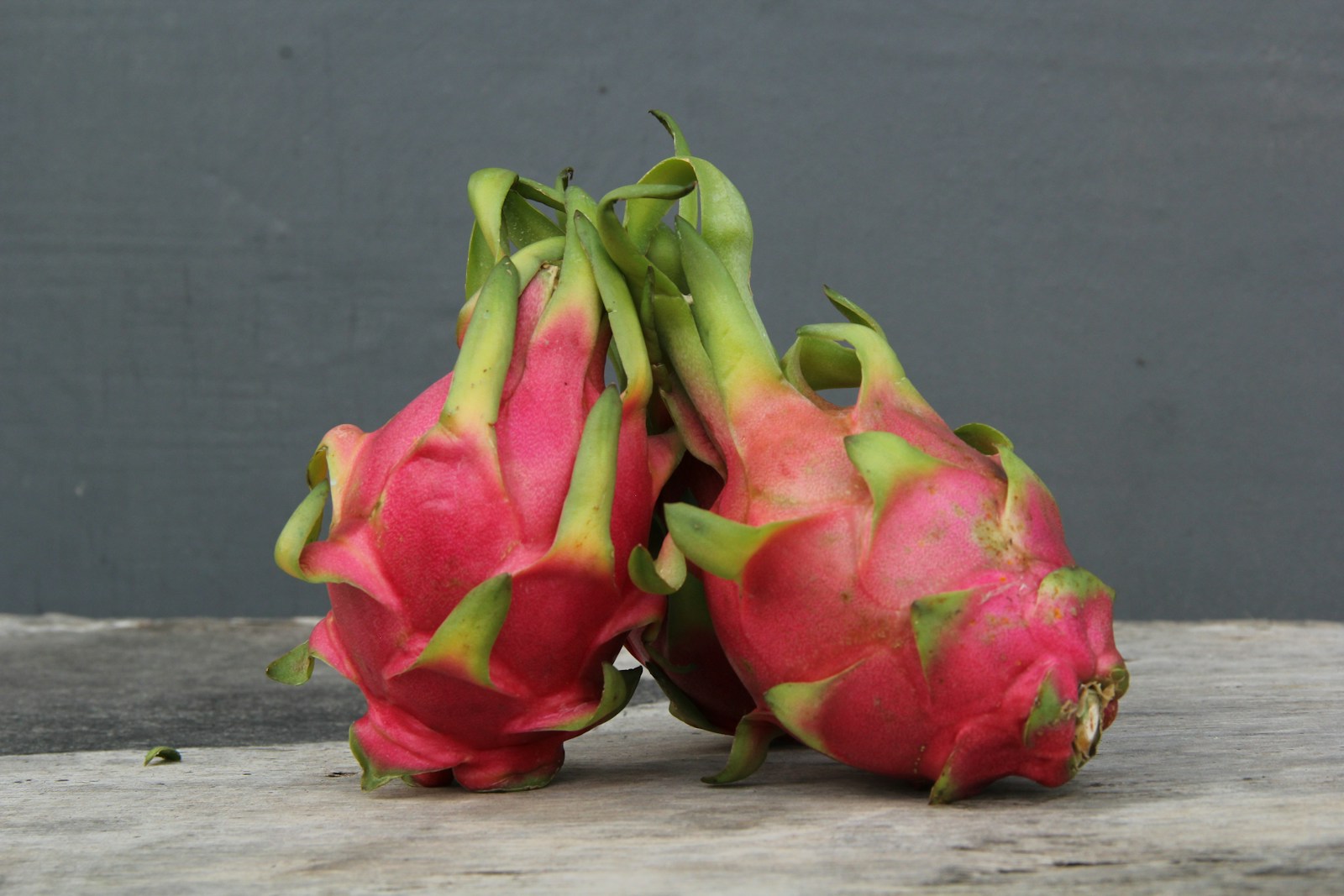 a couple of dragon fruit sitting on top of a wooden table