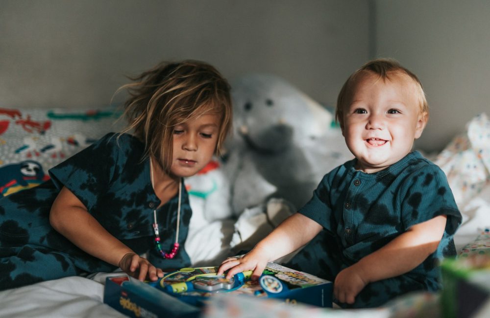 girl in blue and black crew neck t-shirt sitting beside white polar bear plush toy