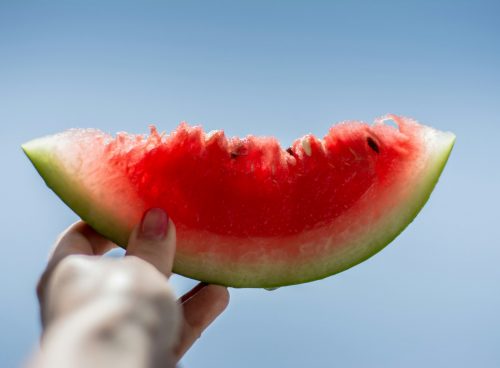 person holding sliced watermelon
