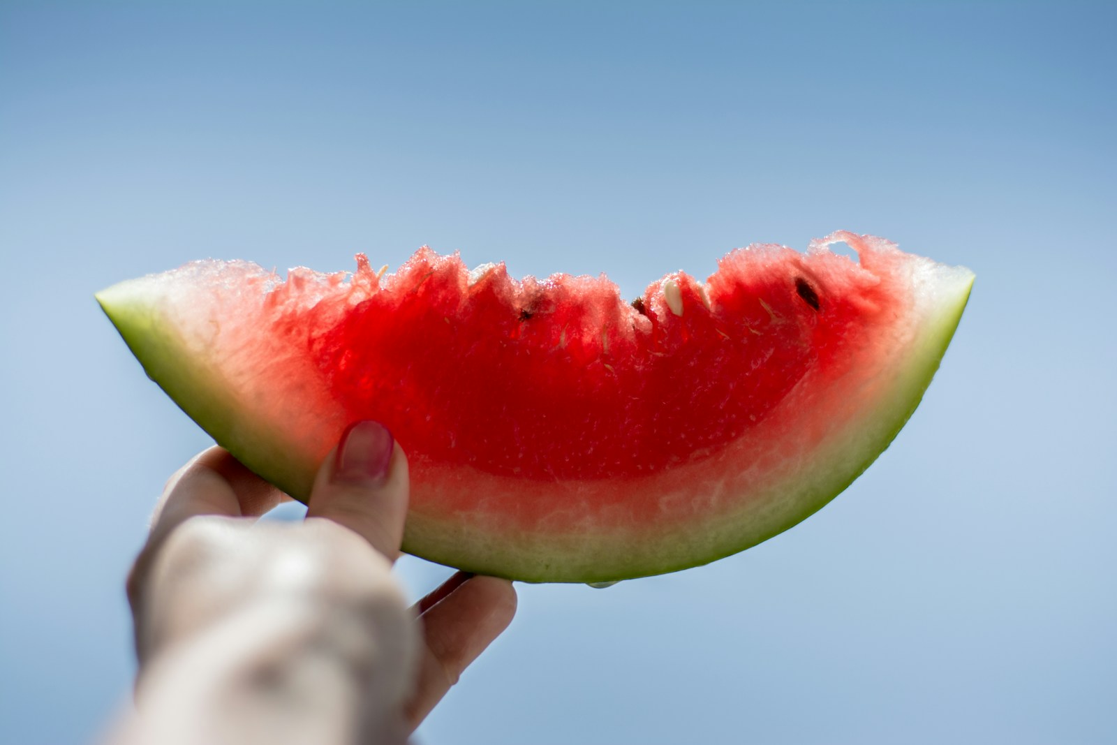 16 Surprising Health Benefits of Watermelon 1 person holding sliced watermelon