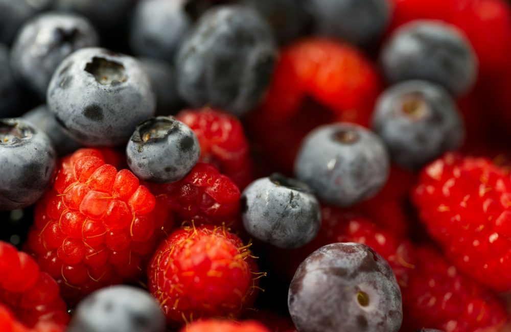 A close up of berries and blueberries in a bowl