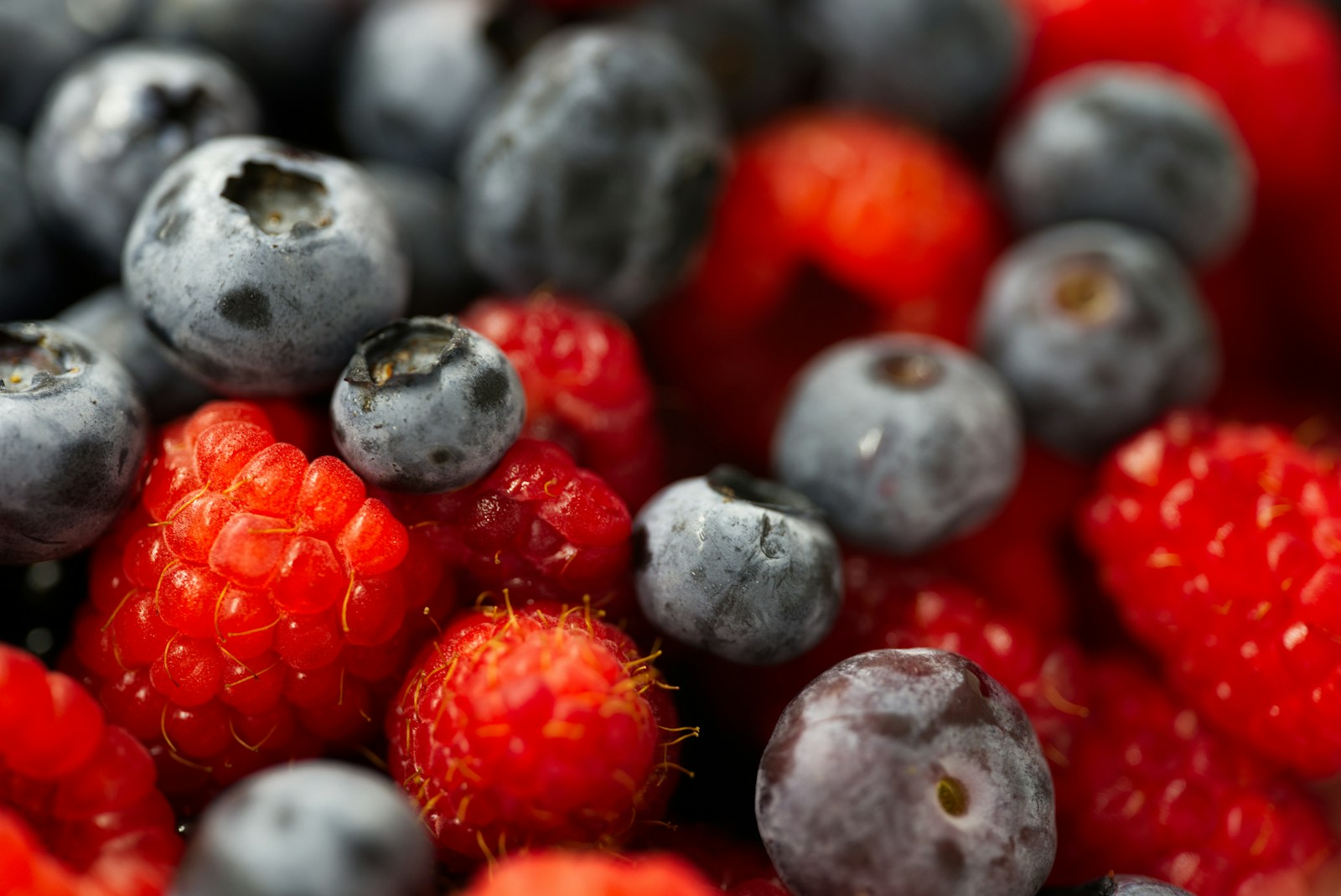 A close up of berries and blueberries in a bowl