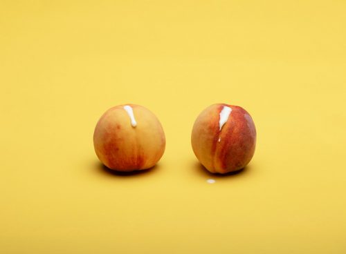 2 red apples on yellow surface