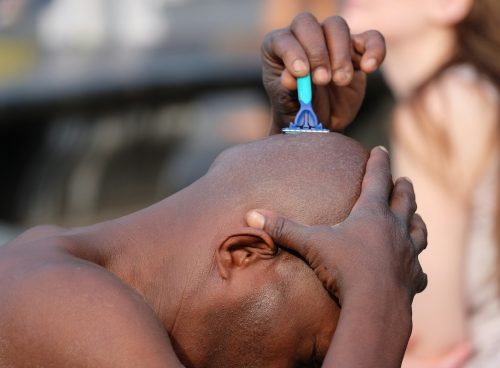 man shaving his head