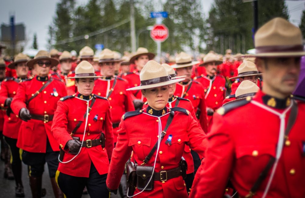 a group of men in red uniforms marching down a street