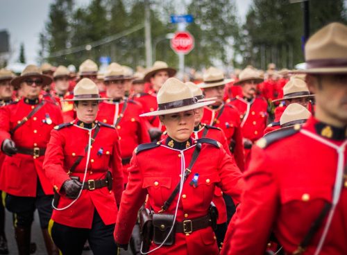 a group of men in red uniforms marching down a street
