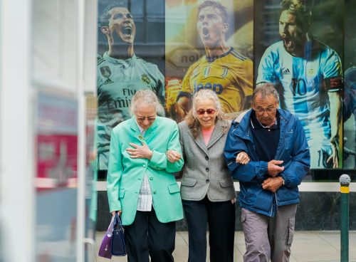 two women and man walking in the street during daytime