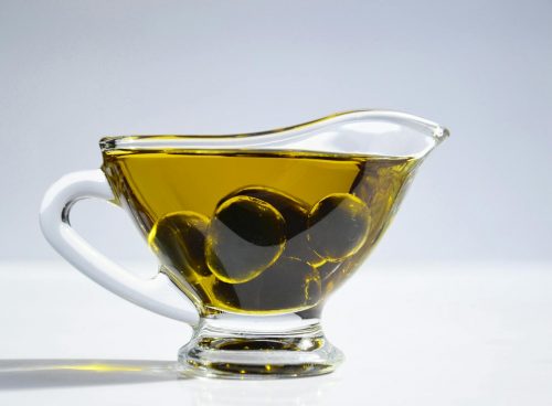 Photo of Olives on Cup of Olive Oil