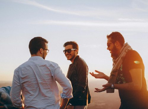 Three Men Standing While Laughing