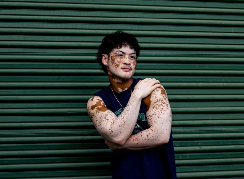 Man Standing against Green Garage Door