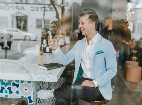 smiling man while holding smartphone