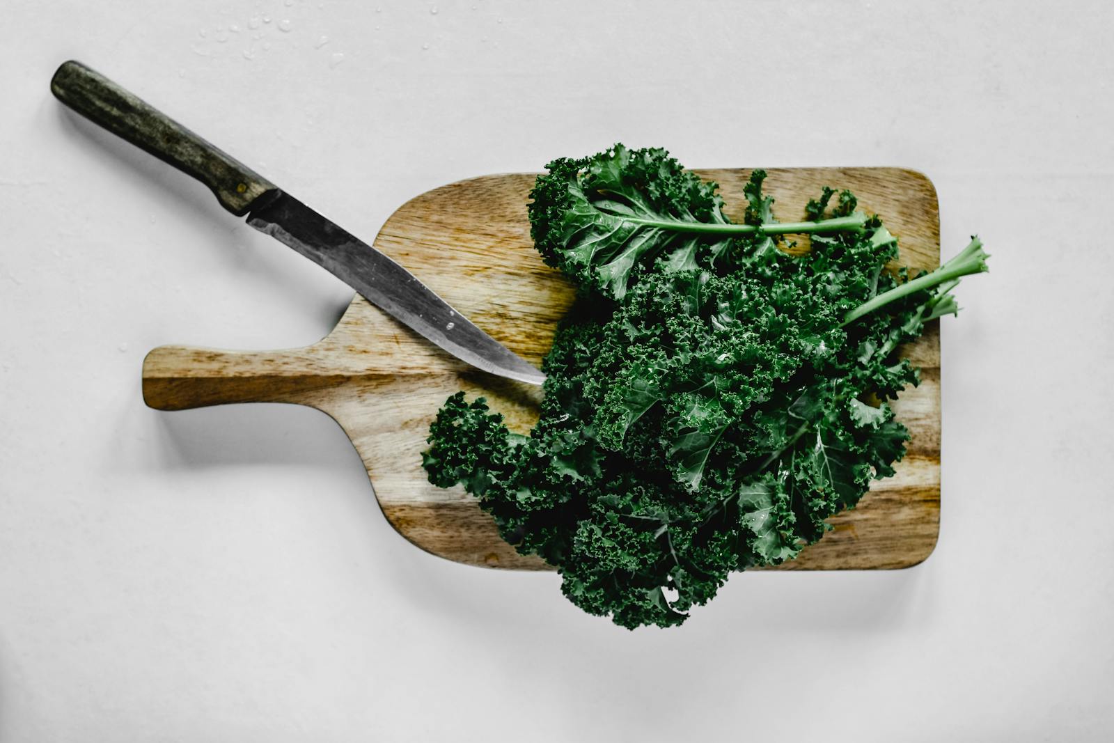14 Best Leafy Greens for People with Vitamin K Needs 1 Close-Up Shot of Kale on a Wooden Chopping Board