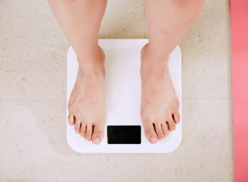 person standing on white digital bathroom scale
