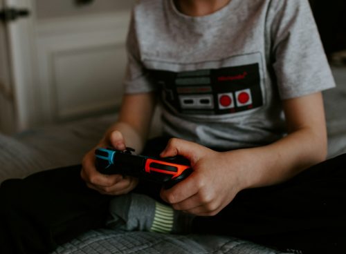 kid sitting on gray bed while playing