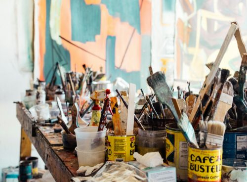 assorted-color paint brush on brown wooden table top